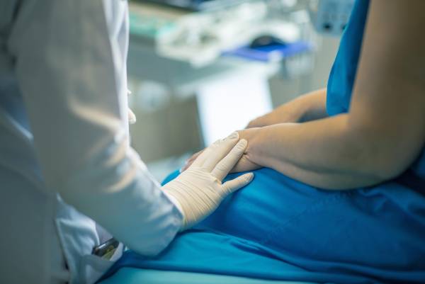 Patient som sitter på sin vårdcentral och får hjälp via privatvården.